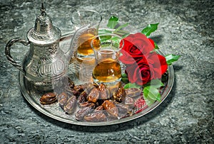 Tea, dates fruits and red rose flowers. Oriental hospitality vintage