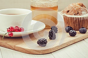 tea with fresh berries, cake and honey/healthy breakfast: tea with fresh berries, cake and honey on a wooden surface