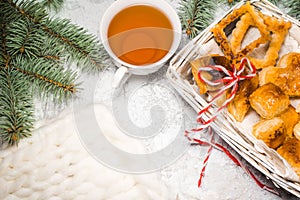 Tea with gingebread cookies in christmas evening. Cup near spruce branch on white wooden background top view copyspace