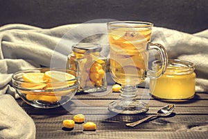 Tea with ginger and lemon in a glass cup and yellow sweets