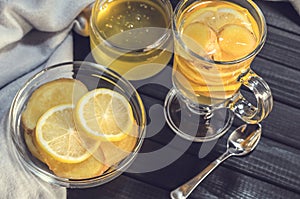 Tea with ginger and lemon in a glass cup and yellow sweets