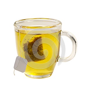 Tea glass of green tea with teabag on white backgr