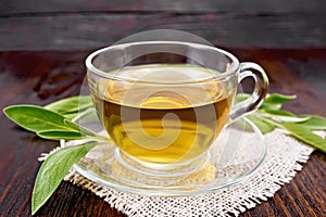 Tea herbal with sage in glass cup on dark board