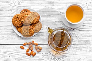 Tea with homemade cookies. Fresh cookies, cup of tea, teapot on white wooden background top view