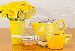 Tea with honey, teapot and bouquet of yellow flowers