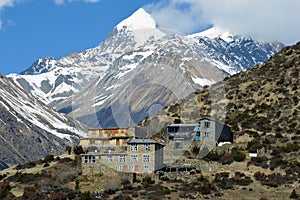 Tea houses on the edge of a mountain side, on the Annapurna circuit. With the snow capped mountains of the Himalayas behind photo