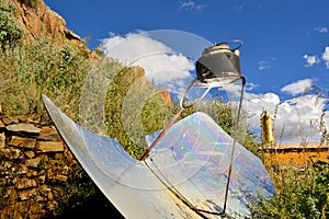 Tea kettle boiling by solar parabolic reflector photo