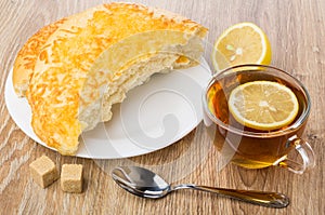 Tea with lemon, broken flat bread with cheese, sugar