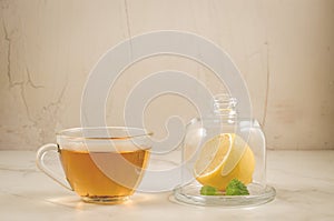 tea with a lemon and leaves of mint/tea with a lemon and leaves of mint on a white background. Selective focus