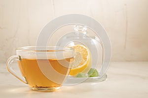 tea with a lemon and mint in glass cup/tea with a lemon and mint in glass cup on a white background, selective focus