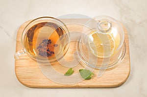 Tea with a lemon and mint/tea with a lemon and mint on a wooden tray on light marble. Top view
