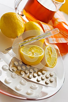 Tea with lemons and flu pills with thermometer - grippe remedy photo