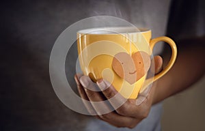 Tea Lover Concept. Hand Holding a Cup of Tea. Eco-Friendly Style Tag made as Heart Shape and Hanging on Cup. Green, Oolong,