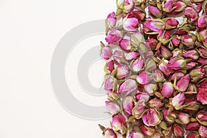 Tea made from dried buds and petals of a pink rose on a white background