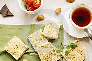 tea, milk, cakes, chocolate pieces, halva on table