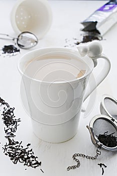 Tea with milk in cracked white porcelain cup with cat