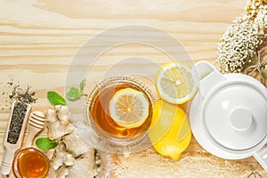 The tea with mint honey ginger and lemon on wood background,warm ton