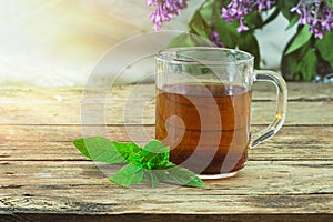 Tea and mint leaves on a wooden background