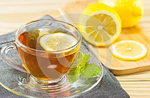 The tea with mint and lemon on wood background,warm toning, selecti
