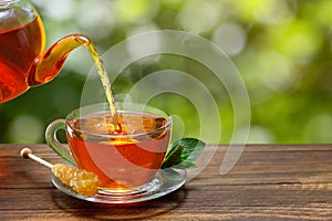 tea with mint pouring from teapot into cup