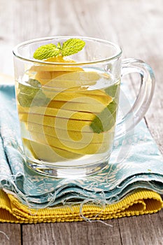 Tea with mint and whole lemon in a transparent cup