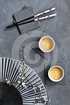 Tea mugs and  cherry  flowers in oriental style, top view