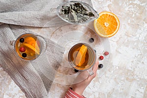 Tea with orange. Dark wooden background. An old book and gingerbreads in the background