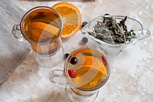 Tea with orange. Dark wooden background. An old book and gingerbreads in the background