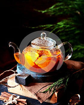 Tea with orange in a glass teapot