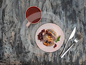 Tea with pancakes with apple filling and apple jam, in pink ceramic dishes and cutlery