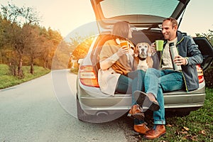 Tea party in car truck - loving couple with dog sits in car truck