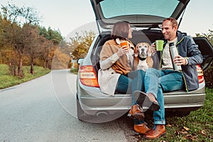 Tea party in car truck - loving couple with dog sits in car truck