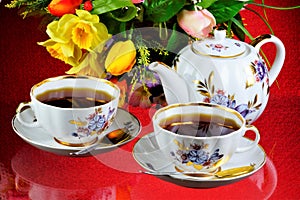 Tea party - tea in cups, teapot, garden flowers on a summer day. Daily tea is a delicious, popular, healthy, invigorating drink