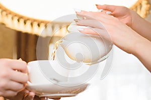 Tea party. Women pour green tea into a white Cup