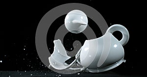 Tea-Pot falling and exploding on Black Background