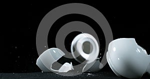 Tea-Pot falling and exploding on Black Background