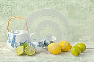 Tea pot and lemons on grunge table