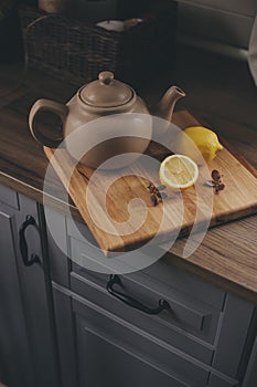 Tea pot and lemons in rustic grey kitchen interior. Slow living in country house concept