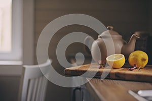 Tea pot and lemons in rustic grey kitchen interior. Slow living in country house concept