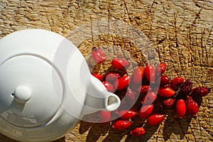 Tea Pot With Rose Hips On Wooden Background