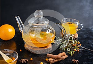 Tea pot with sea buckthorn beverage with honey, orange, cinnamon. anise stars