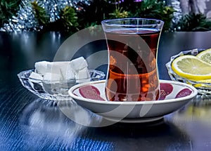 Tea poured into a glass of Armud with lemon and sugar