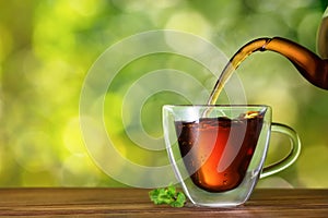 tea pouring from teapot into cup