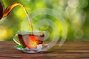 tea pouring from teapot into cup