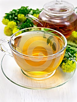 Tea of Rhodiola rosea in cup with teapot on board