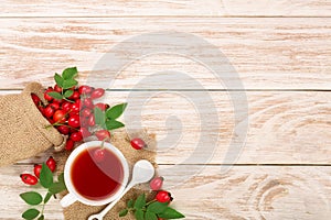 Tea with rose hips and honey on white wooden background with copy space for your text. Top view