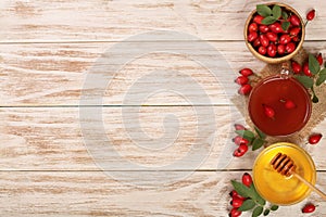 Tea with rose hips and honey on white wooden background with copy space for your text. Top view