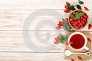 Tea with rose hips and honey on a white wooden background with copy space for your text. Top view