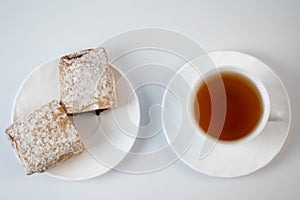 Tea on a saucer with sweet pastries