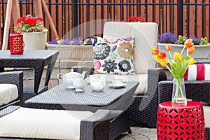 Tea served on an outdoor patio between flowers